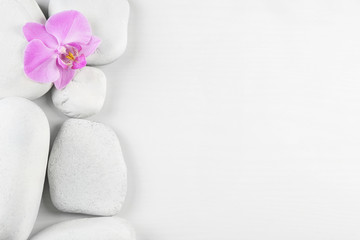 Spa stones with orchid flower on white background