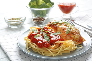 Delicious pasta with chicken parmesan and sauce on plate