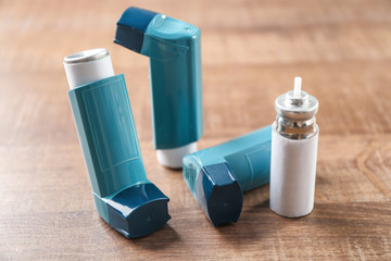Asthma inhalers with cartridge on wooden table