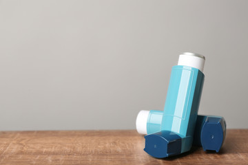 Asthma inhalers on wooden table