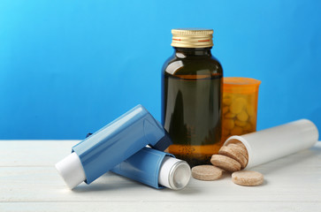 Asthma inhalers with medicines on blue background