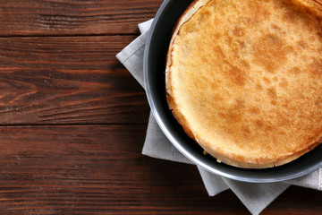 Tasty pancakes on pan on wooden table