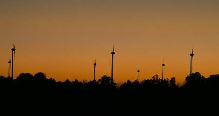Naklejka premium Orange sunset with windmill silhouettes