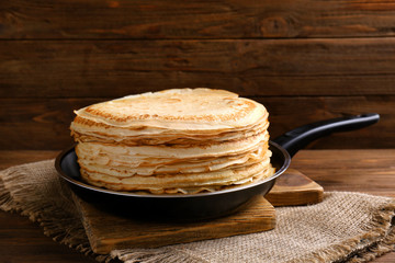 Tasty pancakes on pan on cutting board