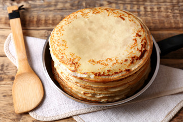 Tasty pancakes on pan on table