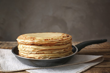 Tasty pancakes on pan on table