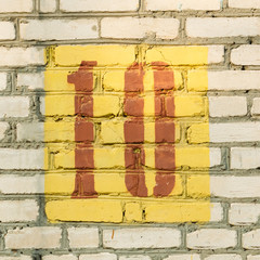 Brick wall with a stencil figure ten on it