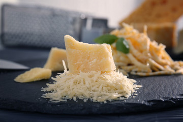 Slate plate with different grated cheese on table