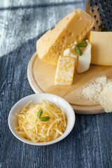 Bowl with grated cheese on wooden table