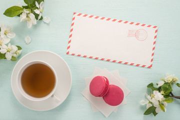  Envelope, flowers, and macarons with cup of tea
