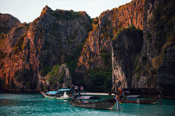 Beach with mountains and long tail boats in Phi Phi island, Thailand