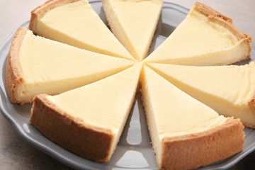 Plate with tasty homemade cheesecake on kitchen table, closeup