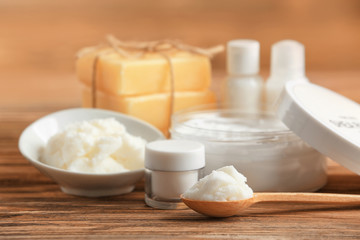 Composition of Shea butter with cosmetic products on wooden table