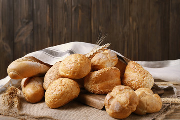 Fototapeta premium Different bread covered with napkin on wooden background