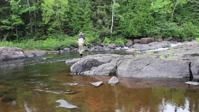 Un p&ecirc;cheur &agrave; la mouche fait des lancer sur un rocher
