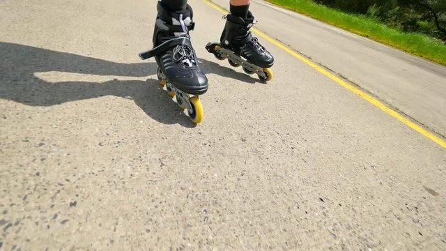 Outdoor shuffle inline skating. Mans legs roller skating on the asphal. Close up view to quick shuffle movement of inline boots.