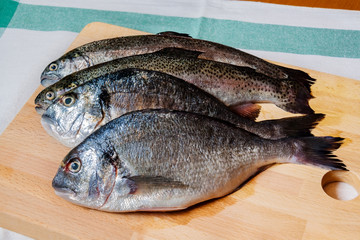 Fresh fish on wooden cutting board