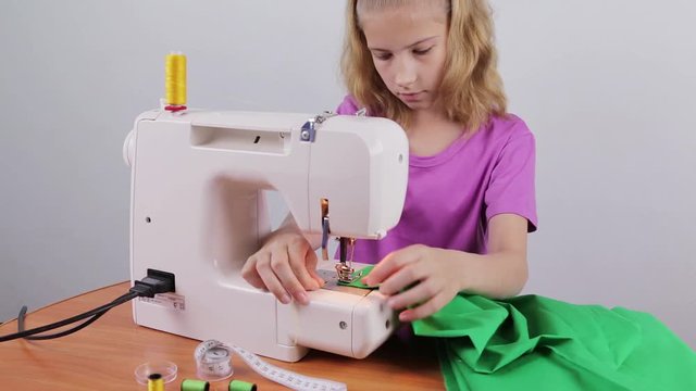 A teenage girl makes a string of thread