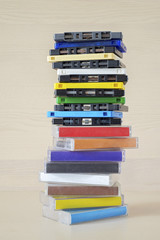 Stack of old colorful dirty audio cassettes and cases on the brown wooden shelf - 156978243