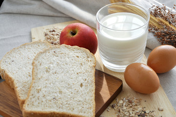 Wheat Bread and Glass of Milk on Background