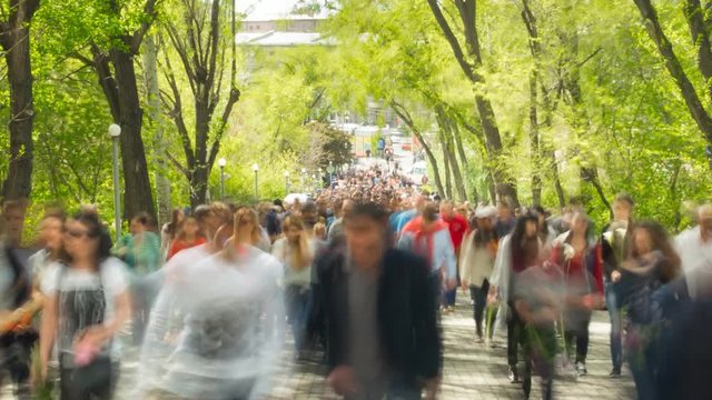 Time lapse of crowd of people walking at you with blurred images on the background of nature