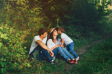 Happy young family spending time together outside in green nature.