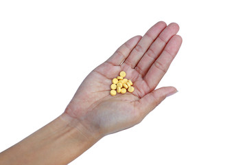 Female hand with yellow pill in palm on white background.