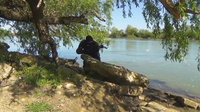 A Russian special forces soldier in armor and balaclava targets a crossbow and changes his position. Marine recon.