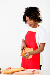 Young woman splitting a piece of bread in order to put some avocado there.