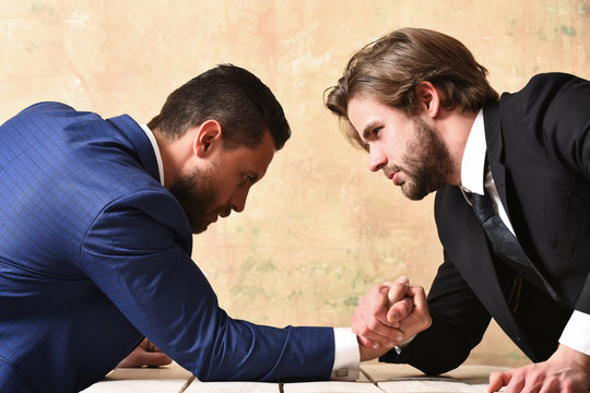 two businessmen doing arm wrestling, winning and loss