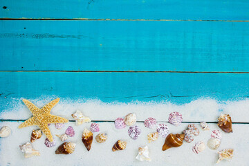 Blank antique teal blue wood beach sign with seashells and sand border; wooden background with copy space