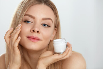 Obraz na płótnie Canvas Beauty Face Care. Young Female Model Putting Cream On Eye Skin