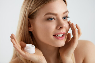Beautiful Woman Applying Cream On Skin Under Eyes
