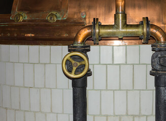 Production of beer old system of pipes with valve filling of copper vats for cooking against white...