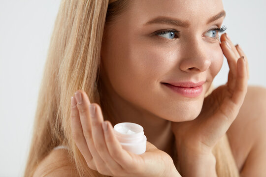 Woman Face Skin Cosmetics. Girl Applying Cream Under Eyes