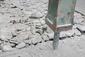 A hydraulic hammer breaks a road of paving stones