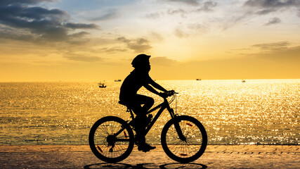 Fototapeta na wymiar Girl cycling at the beach twilight time