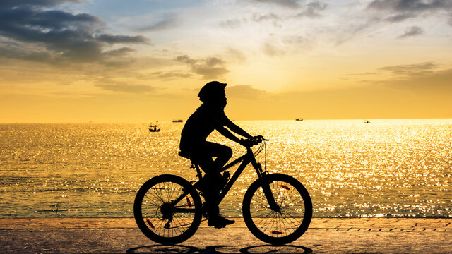 Girl cycling at the beach twilight time