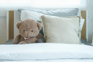 Brown bear and pillows on bed in child's bedroom