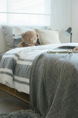 Brown teddy bear on bed in child's modern bedroom interior