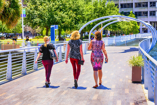 Three women walking along the Riverwalk in downtown Tampa FL