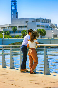 Two young people taking time out on the Riverwalk in downtown Tampa FL