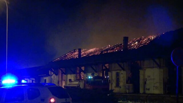 a fire in a warehouse at night - roof in flames