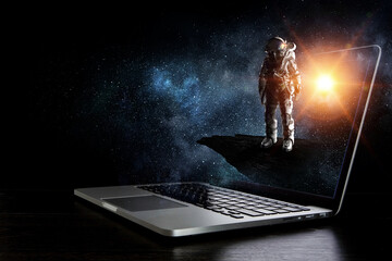 Space explorer and laptop. Mixed media