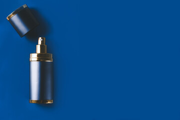 Bottle of man perfume on blue dark background with copy space