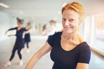 Active senior woman smiling and looking at camera performing ballet