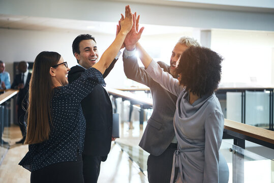 Cheerful multiethnic office team giving high five