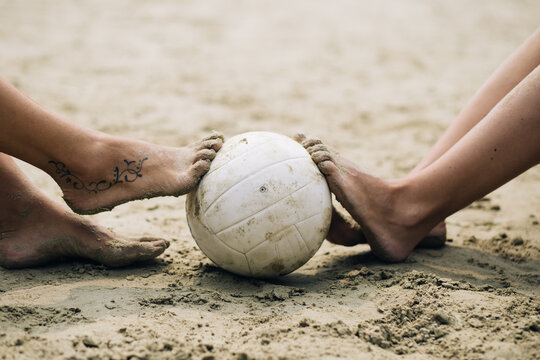 Beach volleyball, people outdoors. Women resting after playing beach volleyball. Selective focus on ball.