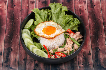 Jasmine rice topped stir - fried spicy basil with meat.