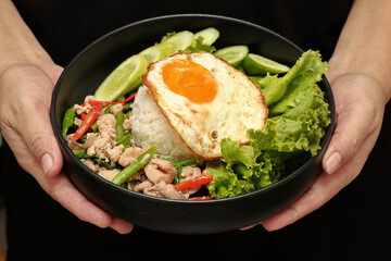 Jasmine rice topped stir - fried spicy basil with meat.